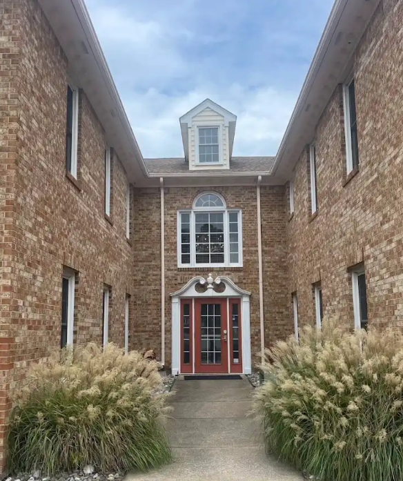 Brick office building entrance at 3630 South Plaza Trail with ornamental grasses lining the walkway