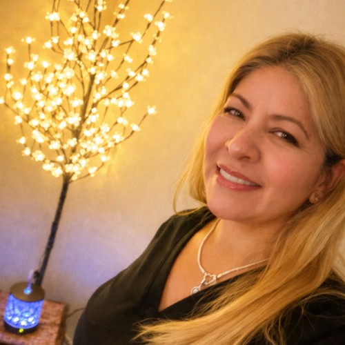 Ingrid Medina smiling beside a lit branch lamp in the spa